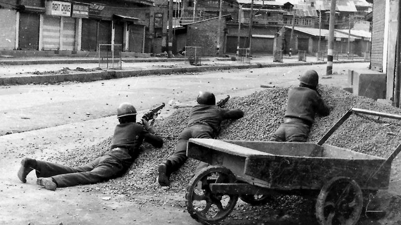This photograph taken in 1989 shows Indian policemen taking positions after Kashmiri militants opened fire on government forces in the old city area of Naid Kadal in Srinagar.