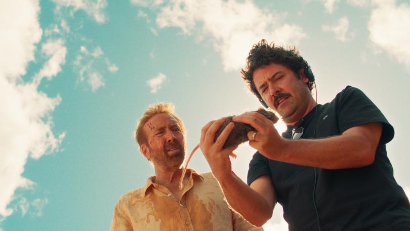 Lorcan Finnegan holding a story-significant rat on the set of The Surfer.