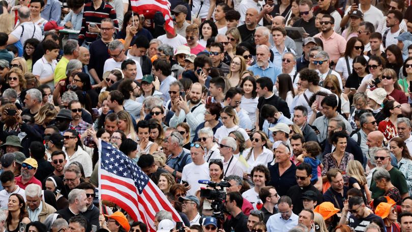 Members of the crowd hold American flags in St. Peter's Square on May 11, 2025 in Vatican City, Vatican.