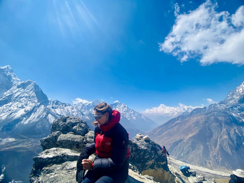 Sarah Steger rests at the top of Nangkartshang Peak (5090m) after an acclimatisation hike from Dingboche.