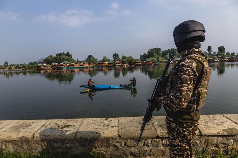 An Indian paramilitary soldier stands watch on the bank of Dal lake.