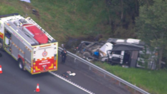 A driver is dead and a passenger fighting for life after a car towing a caravan plunged into a creek off a major highway.