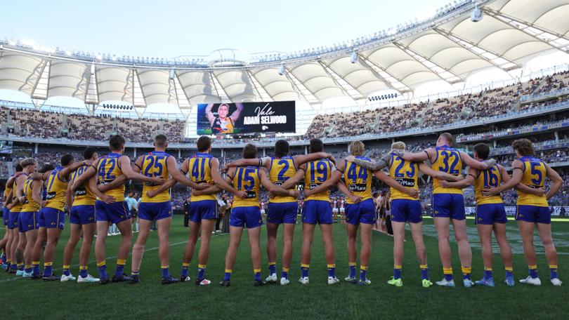 Eagles players linking arms and paying tribute to Adam Selwood.