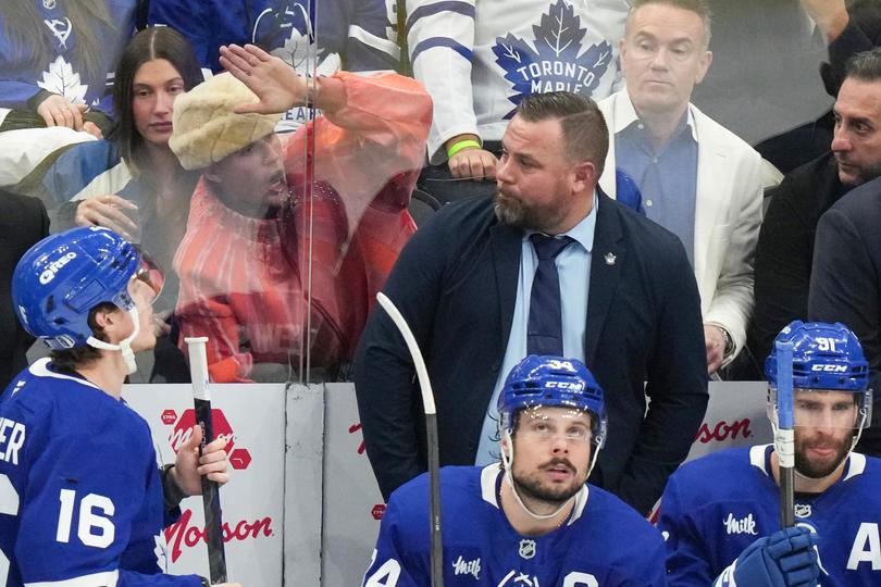 Justin Bieber, second left in the background, bangs on the glass as he sits behind the Toronto Maple Leafs bench.