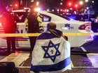A man draped with an Israeli flag sits where two people were killed near the Capital Jewish Museum. 