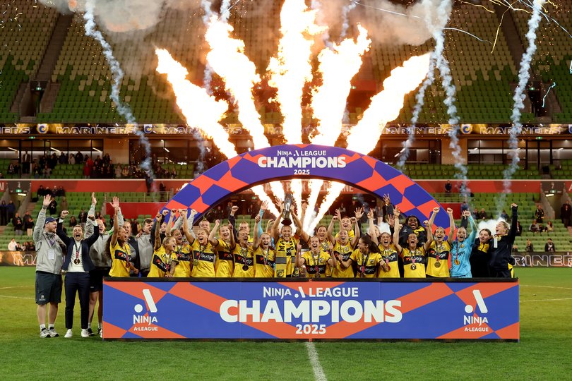 The Mariners hold aloft the championship trophy in front of empty stands at AAMI Park.