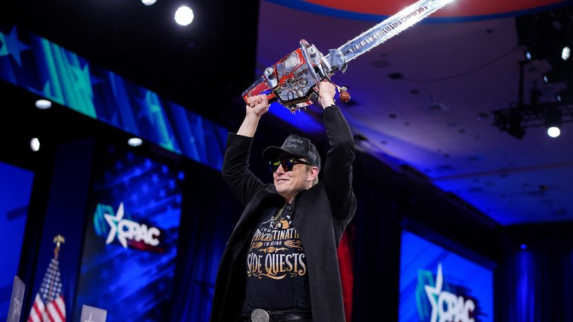 SpaceX Elon Musk wields a chainsaw as he leaves the stage at the Conservative Political Action Conference on February 20, 2025.