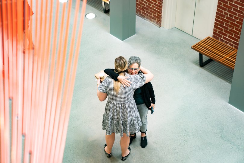 People hug at the museum’s reopening Thursday.