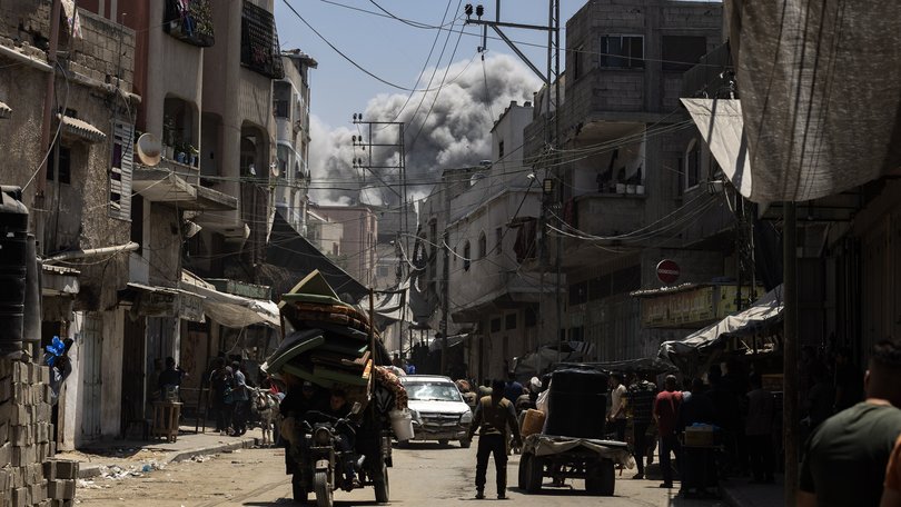 Smoke billows in the distance as Palestinians in Jabalia fled on Friday, May 30, 2025, after the Israeli military issued a sweeping new evacuation order for much of northern Gaza.