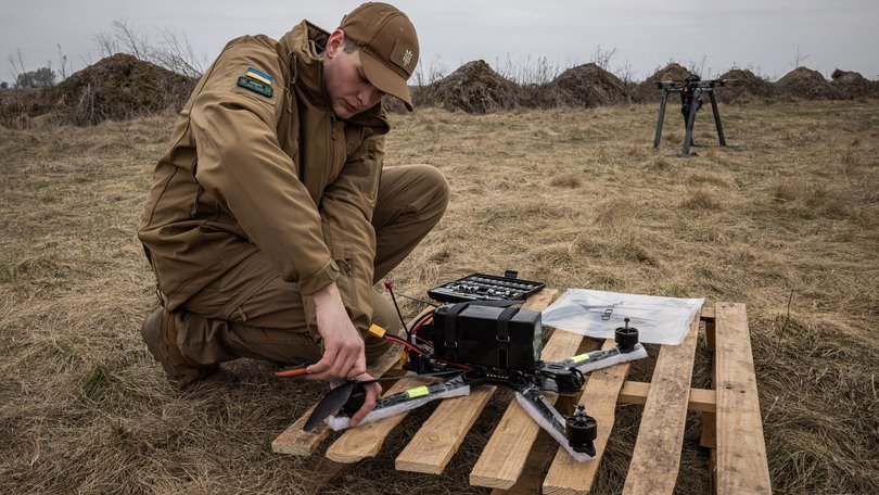 Dmytro Romanchenko, 22, director of Raptor Engineering, adjusts parts of fps front before flying a fiberoptic controlled FPV drone from a launch pad.