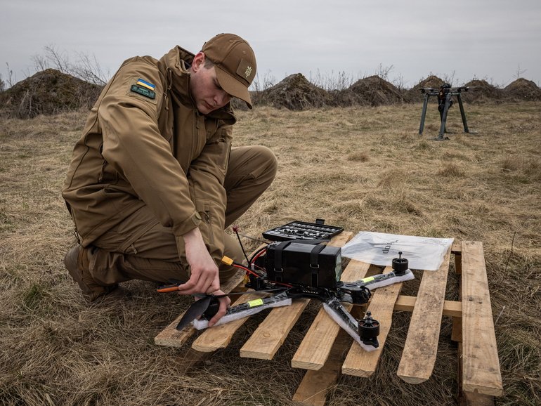 Dmytro Romanchenko, 22, director of Raptor Engineering, adjusts parts of fps front before flying  a fiberoptic controlled FPV drone from a launch pad.