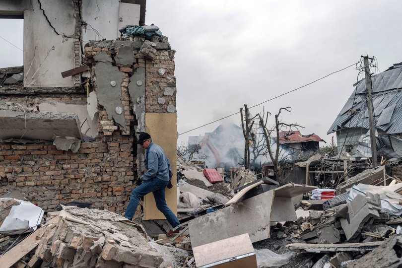 A resident walks over rubble following a Russian missile attack in Kyiv, on May 25. MUST CREDIT: Andrew Kravchenko/Bloomberg