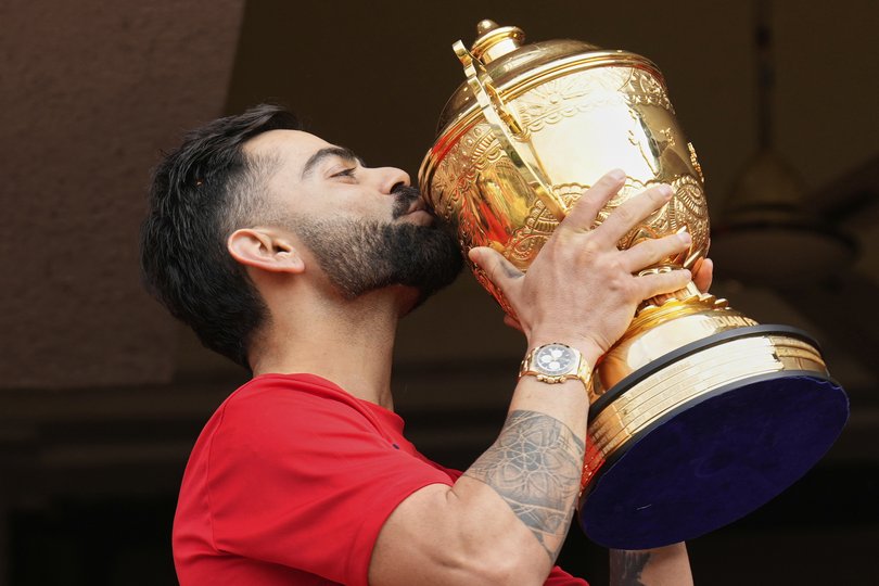 Royal Challengers Bengaluru's Virat Kohli kisses the Indian Premier League winners' trophy at the parade.