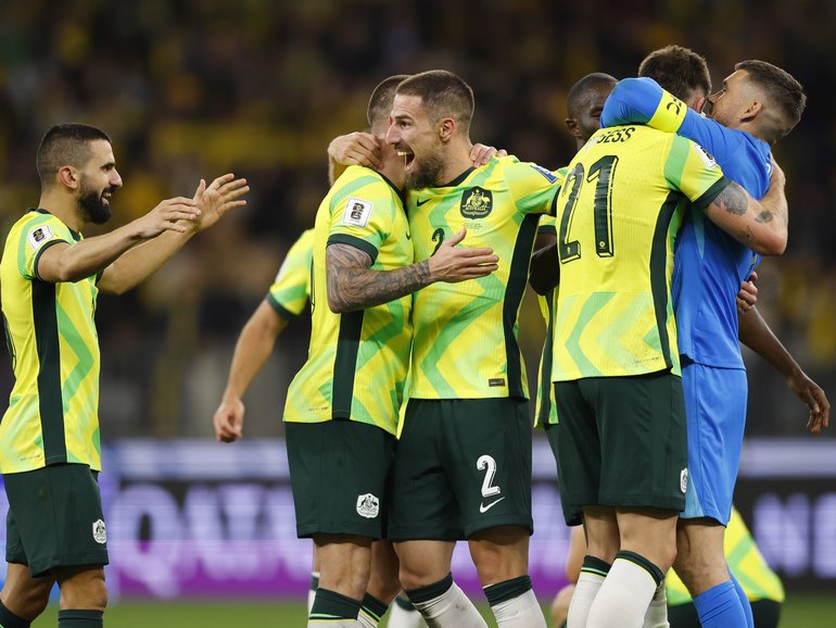 The Socceroos celebrate their late win over Japan.
