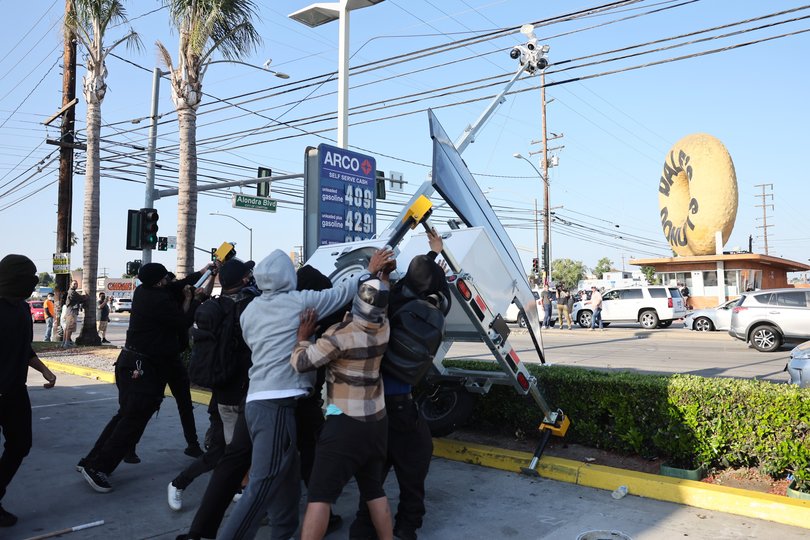 Protesters destroy a mobile police surveillance post during a clash with federal agents. EPA/ALLISON DINNER