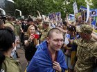 Some women held up pictures of missing relatives as released Ukrainian soldiers returned home. (AP PHOTO)