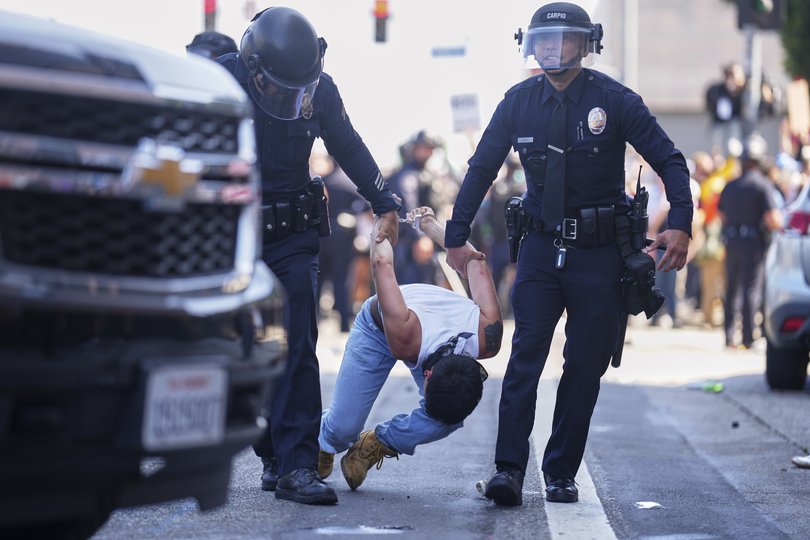 A protestor is detained in downtown Los Angeles, Sunday, June 8, 2025, following last night's immigration raid protest. (AP Photo/Eric Thayer)