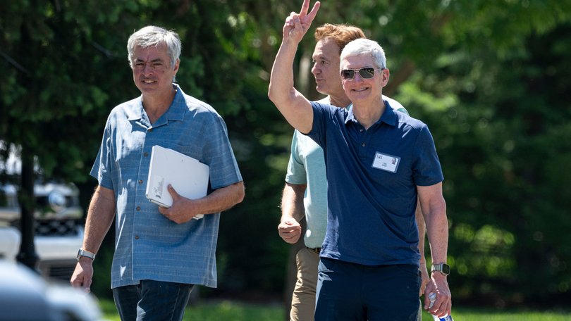 Eddy Cue, senior vice president of services at Apple Inc., from left, Steve Pagliuca, co-chairman of Bain Capital LLC, and Tim Cook, chief executive officer of Apple.