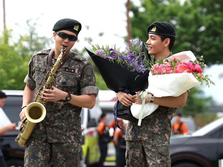 BTS members RM and V play to the crowd after the military discharge.
