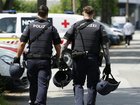 Two policemen walk past ambulance cars in a street close to a school where, according to reports, several people died in a shooting, on June 10, 2025 in Graz, southeastern Austria.