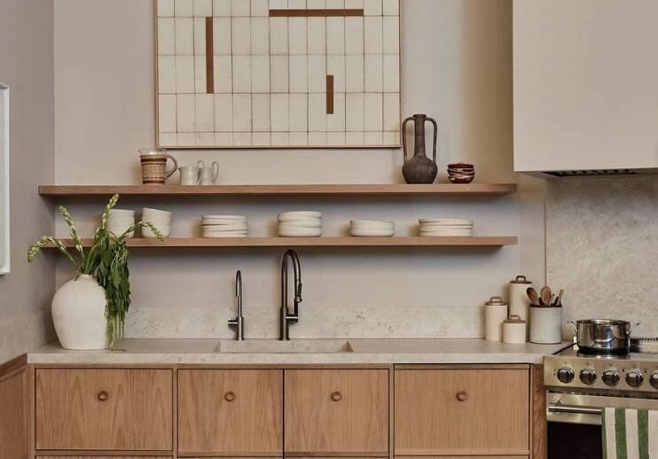 An oak panelled kitchen features warm neutrals and stone bench tops. Pic: Instagram/archdigest.