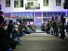 Protesters kneel in the street facing a row of police in riot gear during a protest in response to federal immigration operations in the Little Tokyo neighborhood of downtown Los Angeles, on June 9, 2025. President Donald Trump's administration said on June 9 that it was sending 700 US Marines and thousands more National Guard troops to Los Angeles, sparking a furious response from California's governor over the "deranged" deployment. Protests in Los Angeles, home to a large Latino population, broke out on June 6, triggered by immigration raids that resulted in dozens of arrests of what authorities say are illegal migrants and gang members. (Photo by Frederic J. Brown / AFP)