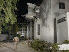 The tail of the Air India flight that crashed shortly after takeoff protrudes from a medical college hostel on June 12, 2025 in Ahmedabad, India. 