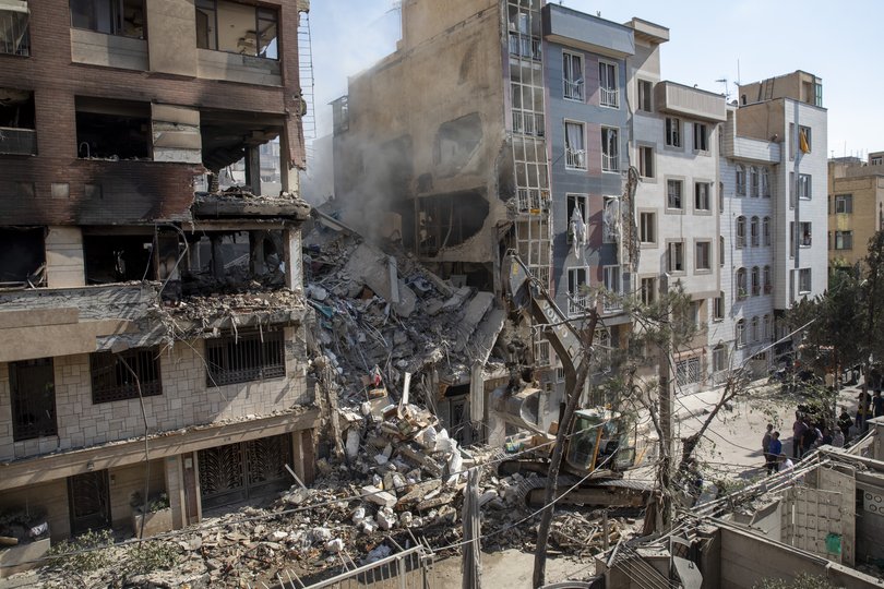 An excavator removes debris from a residential building that was destroyed in Tehran.