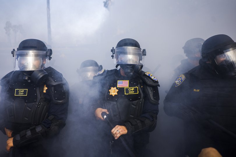 Police officers move to counter activists protesting immigration raids.