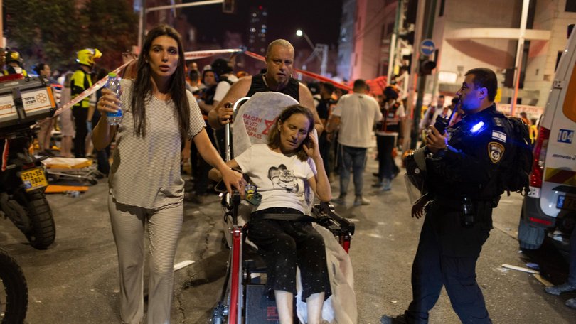 Israelis move an injured Israeli woman to an ambulance near a building hit by a ballistic missile launched from Iran in Bat Yam, Israel, on Sunday, June 15, 2025.