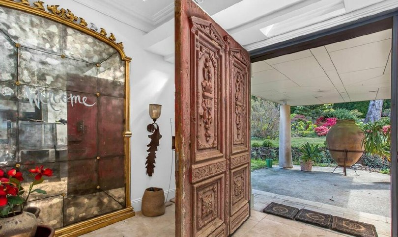 The entry to the home featuring a carriage door from Italy.