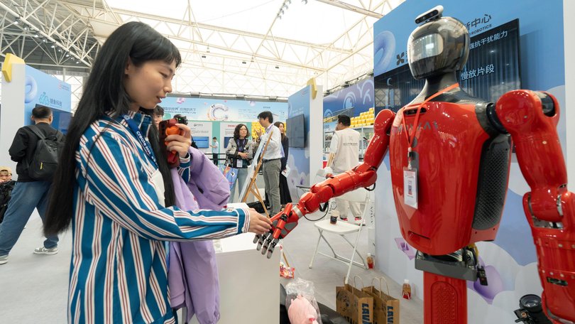 An attendee interacts with a humanoid robot during the Baidu Inc. Create AI Developer Conference in Wuhan, China.