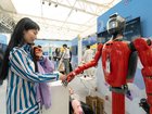 An attendee interacts with a humanoid robot during the Baidu Inc. Create AI Developer Conference in Wuhan, China.