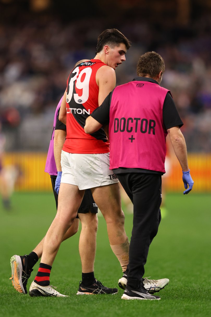 PERTH, AUSTRALIA - JUNE 19: Vigo Visentini of the Bombers is walks from the field with team medical staff after a tackle on Matthew Johnson of the Dockers during the round 15 AFL match between the Fremantle Dockers and Essendon Bombers at Optus Stadium, on June 19, 2025, in Perth, Australia. (Photo by Paul Kane/Getty Images)