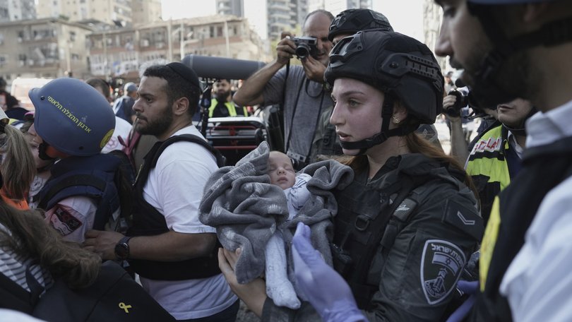 A baby is evacuated from the site of a direct hit from an Iranian missile strike in Ramat Gan, Israel, Thursday, June 19, 2025.