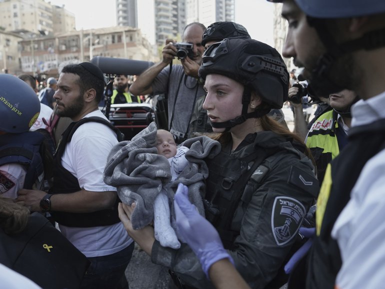 A baby is evacuated from the site of a direct hit from an Iranian missile strike in Ramat Gan, Israel, Thursday, June 19, 2025. 