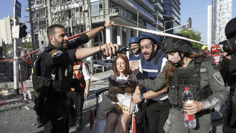 A woman is evacuated from the site of a direct hit from an Iranian missile strike in Ramat Gan, Israel.