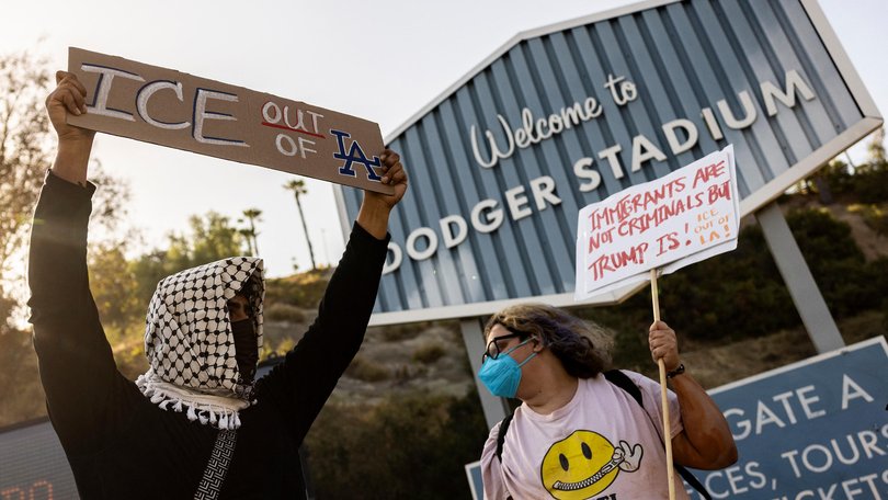 A small group of demonstrators protests outside the entrance of Dodger Stadium.