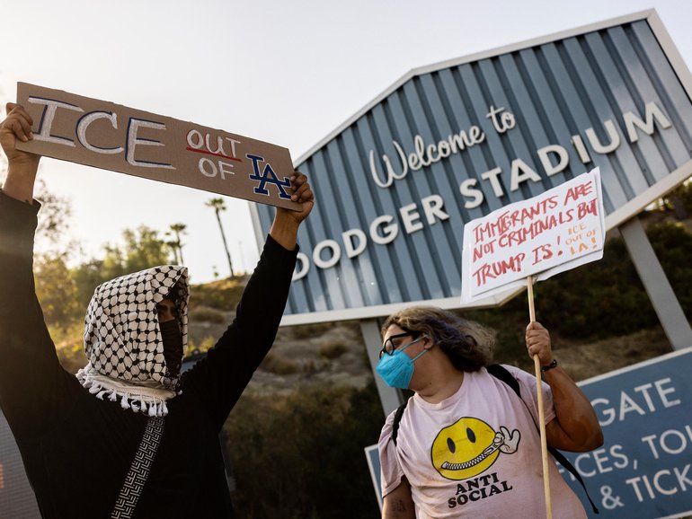 A small group of demonstrators protests outside the entrance of Dodger Stadium.