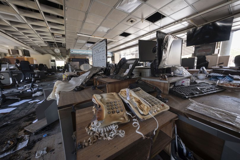 Melted telephones and computers are pictured in a newsroom at the headquarters of Iran's state television compound.