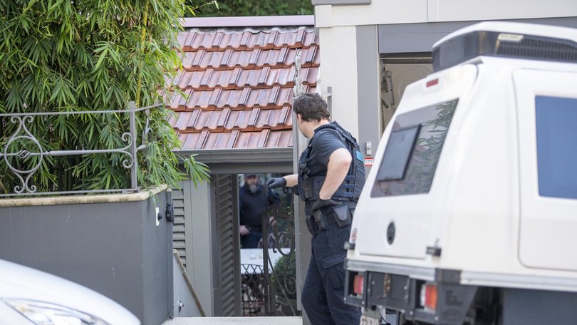 An officer loiters out the front of the luxury home as investigators comb through the premises.
