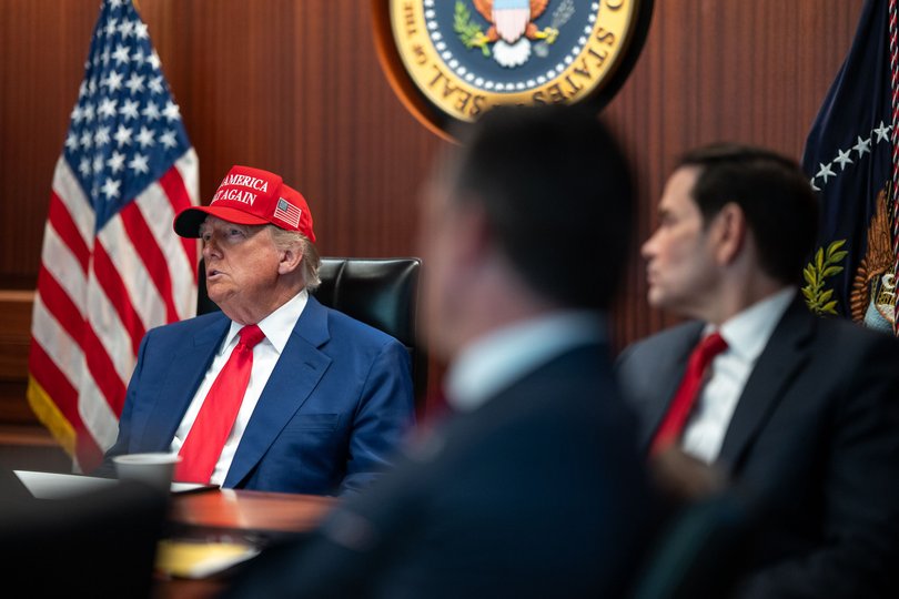 Mr Rubio looks to President Trump.
