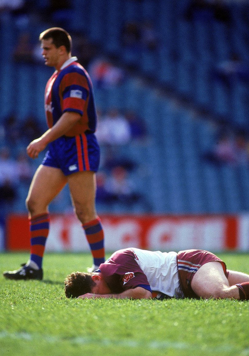 Mark Carroll lies on the ground as Paul Harragon walks past during the 1997 ARL Final series.