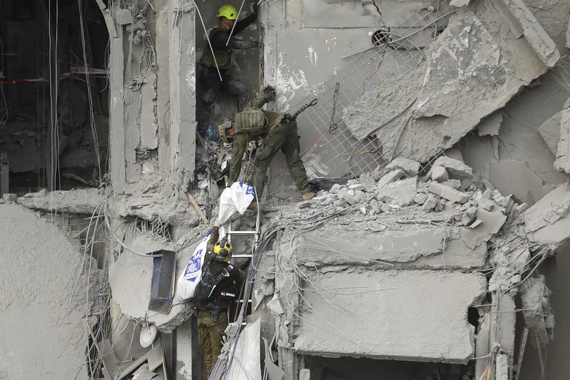 Emergency responders work at a building where at least four people died in a missile strike in Beersheba, Israel.