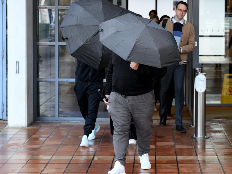 Adam Abdul-Hamid's family shielded themselves with umbrellas and swore at the media as they left court.