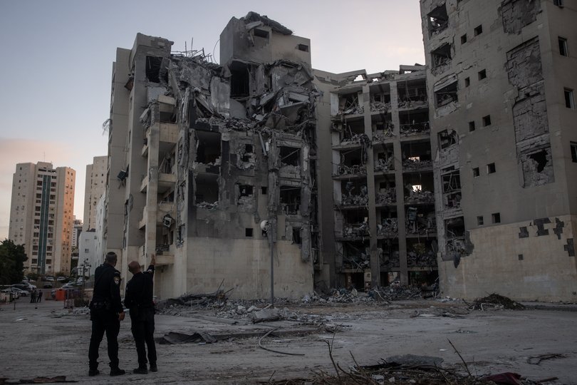 BEERSHEBA, ISRAEL - JUNE 24: Police officers look at a building where four people were killed by an Iranian missile strike on June 24, 2025 in Beersheba, Israel. According to Israeli authorities, Iran launched a barrage of missiles in the early hours this morning, before the start of a U.S.-brokered ceasefire between the two countries. The Iranian foreign minister said that, if Israel stopped its attacks as of this morning, Iran would also end its strikes. (Photo by Chris McGrath/Getty Images)