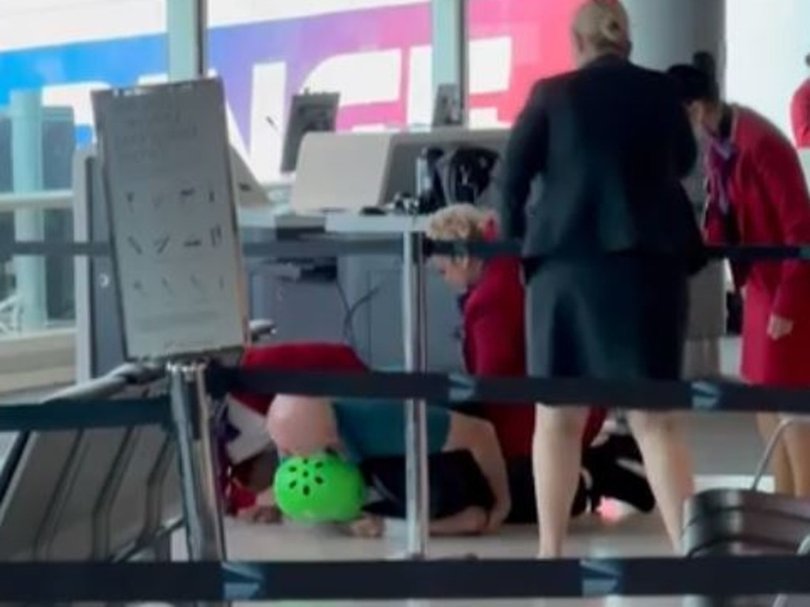 A man is wrestled to the ground in the Virgin terminal at Brisbane's domestic airport.