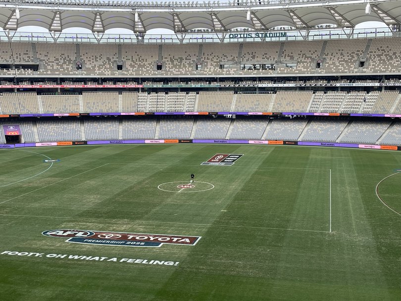 Optus Stadium ground staff mark the lines.