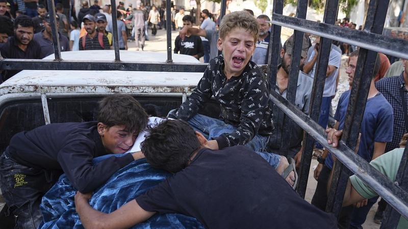 Palestinians children mourn their father, who was killed while heading to an aid distribution hub. (AP PHOTO)