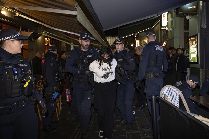 Police escort Anti-Israeli protesters outside an Israeli restaurant Miznon on Hardware Lane in Melbourne.